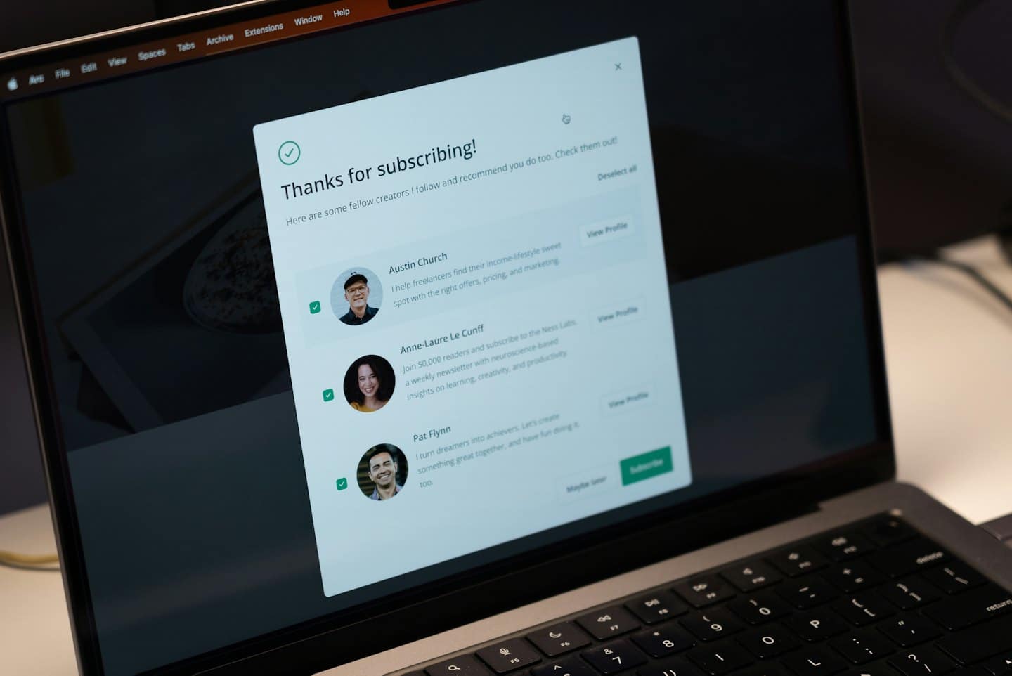 Pantalla de portátil muestra confirmación de suscripción con recomendaciones de creadores.